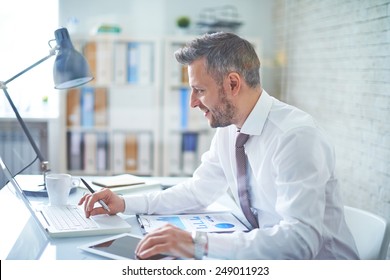 Elegant businessman analyzing data in office - Shutterstock ID 249011923