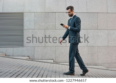 Elegant businessman hand holding and using a smart phone outdoors.