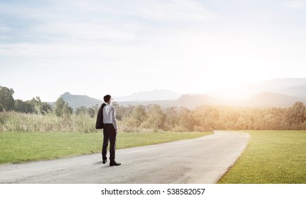 Elegant businessman on road standing with back and looking ahead