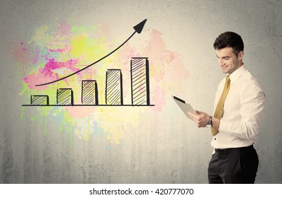 An elegant businessman standing in front of a grey wall with colorful growing chart drawing concept