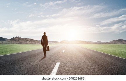 Elegant Businesswoman On Road Standing With Back And Looking Ahead