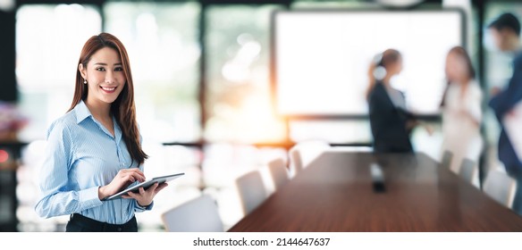 Elegant Businesswoman Standing In Office Meeting Room With Digital Tablet.