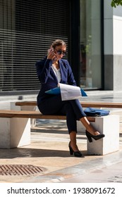 Elegant Bussiness Woman In Marine Blue Suit Sitting On Urban Street Bench Using Mobile Cell Phone