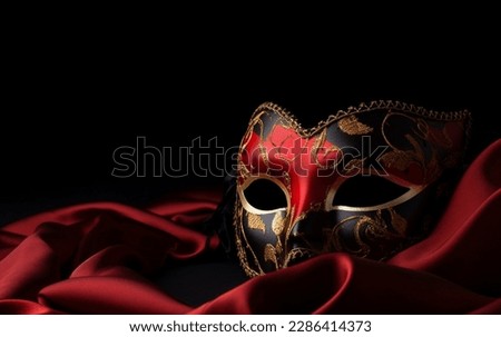 Elegant carnival mask, carnaval, Purim, party , masquerade mask, party gold mask, Venetian mask in gold and red color on red silk
