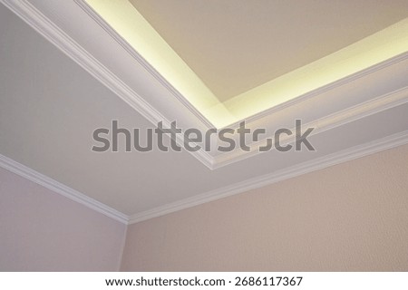Elegant ceiling corner featuring white crown molding and indirect lighting.  Clean lines soft glow