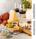 Elegant cheese board featuring a variety of cheeses, grapes, and accompaniments, paired with glasses of red wine