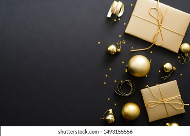 Elegant Christmas Background With Modern Golden Christmas Decorations, Baubles, Gift Boxes, Confetti Stars On Dark Black Backdrop. Flat Lay Design, Top View, Copy Space.