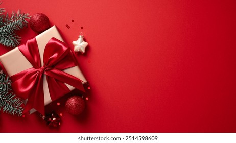 Elegant Christmas gift box with sparkling ornaments and pine branches on vibrant red background - Powered by Shutterstock