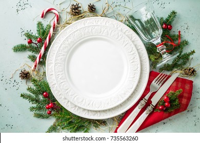 Elegant Christmas Table Setting Design Captured From Above (top View, Flat Lay). Empty White Plate, Glass, Cutlery, Candy Cane And Decorations. Background Layout With Free Text (copy) Space.