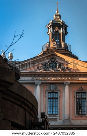 Elegant clock tower of the Swedish Academy basks in the warm glow of the morning sun.