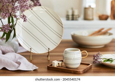 Elegant composition of classy dining room interior design with rustic table, beautiful porcelain, flowers and kitchen accessories. Beauty in the details. Template.