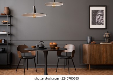 Elegant composition of living room interior with mock up posters frames, round table, lamp, wooden sideboard, rack, dark wall with stucco, vase and personal accessories. Home decor. Template.