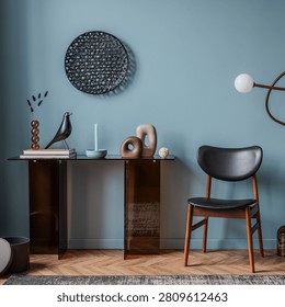Elegant console table with decorative elements like a bird statue, candle, and abstract sculptures, set against a calming blue wall, creating a serene and sophisticated interior mood