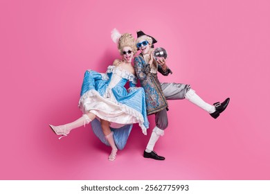 Elegant couple in vintage costumes joyfully poses against a vibrant pink backdrop, capturing the spirit of a themed party or festival - Powered by Shutterstock