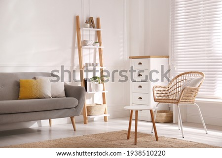 Elegant decorative ladder near sofa in living room