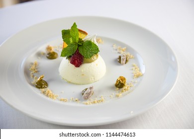 Elegant Dessert On A White Dish With Mint And Red Fruits And Gold Leaf