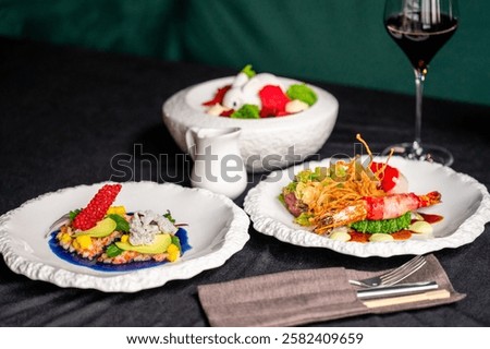 Elegant dining setup featuring a white ornate plate, vintage silverware, a blue linen napkin, and a bright yellow mimosa bouquet on a textured backdrop