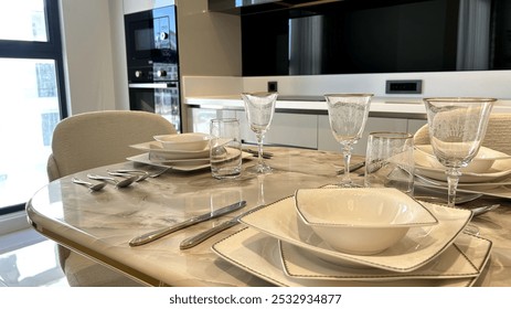 Elegant dining setup in a modern kitchen with marble table and designer glassware, ideal for interior design themes and lifestyle magazines.