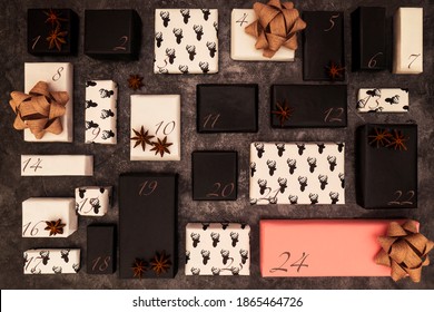 Elegant DIY Advent Calendar Used To Count The Days In Anticipation Of Christmas. Countdown Adult Gifts Wrapped In White And Black Papers And One Special Pink For Christmas Eve On A Dark Background.