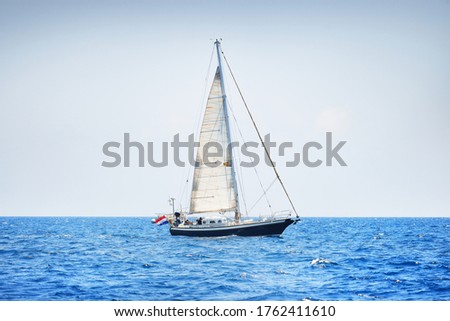 Elegant dutch cruising yacht sailing in a still water of an open Mediterranean sea on a clear day. Idyllic seascape. Summer vacations, leisure activity, sport and recreation, private wessel