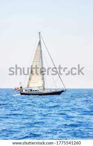Elegant dutch cruising yacht sailing in a still water of an open Mediterranean sea on a clear day. Idyllic seascape. Summer vacations, leisure activity, sport and recreation, private wessel