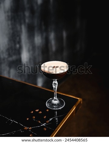 Elegant Espresso Martini with Foam Top and Coffee Bean Garnish on a Dark Table