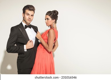 Elegant Fashion Woman Pulling Her Lovers Tuxedo While She Is Looking At Him.