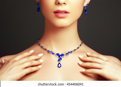 Elegant Fashionable Woman With Jewelry. Beautiful Woman With A Sapphire Necklace. Beauty Young Model With A Diamond Pendant On A Gray Background. Jewellery And Accessories. Beauty And Fashion Concept