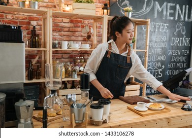 elegant female barista preparing customer meal in bar counter at modern cafe. young girl coffeehouse staff ready for hot coffee and croissant pressing ring. worker ringing service bell calling waiter - Powered by Shutterstock