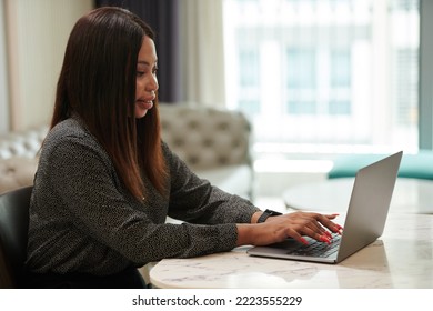 Elegant Female Entrepreneur Working On Laptop At Table In Her Tiny Apartment