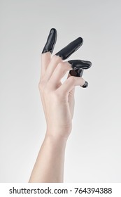 Elegant Female Hand, Fingers Dipped In Black Paint Or Latex On A Light Background