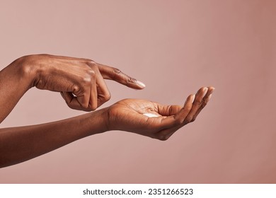 Elegant female hands with moisturizing cream closeup. Black woman applying organic cream on hands isolated on brown background. Close up shot of beautiful female hands holding nourishing cream. - Powered by Shutterstock