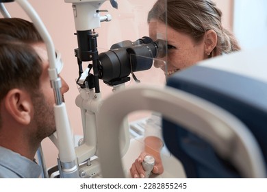 Elegant female looking for problems and caring for eyes in ophthalmology center - Powered by Shutterstock