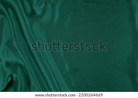 Elegant flowing green silk background with copy space.