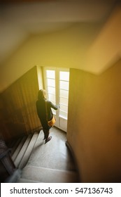 Elegant French Woman Descending Stairs In Old Luxury Building And Opening The Balcony French Window 