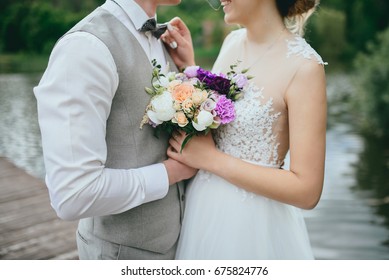 Elegant gentle stylish groom and bride near river or lake. Wedding couple in love