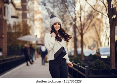 Elegant Girl Walk In A Winter City. Woman In A White Knited Sweater. Beautiful Lady With Dark Hair.