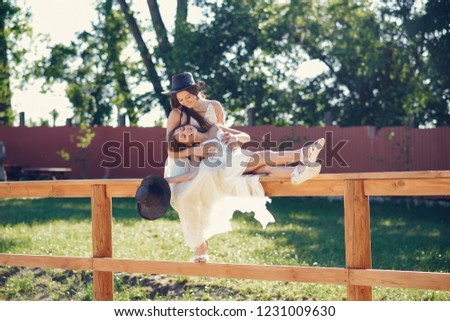 Elegant girls in a long white dress. Ladies with horse. Two sisters in a hats