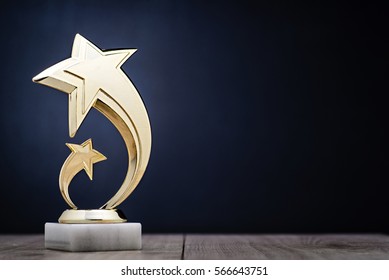 Elegant Gold Winners Trophy With Shooting Stars To Be Awarded For The First Place In A Competition Or Championship Over A Dark Blue Background With Copy Space