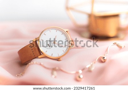 Elegant gold women wristwatch with gold case and leather strap.