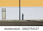 Elegant gray and orange facade with roof gutter in the middle. Concrete sidewalk and urban street in front. Background for copy space.