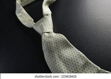 Elegant gray tie on a black background in the style fifty shades of gray