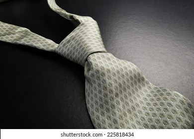 Elegant gray tie on a black background in the style fifty shades of gray