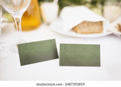 Elegant green cardboard place cards with empty copy space on a wedding table. Perfect for personalized guest seating arrangements. Stylish and simple touch for any wedding reception. - Powered by Shutterstock