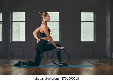 elegant gymnastics teacher inverted hands support body on floor and legs on pilates ring with stretch body develop softness in gray wall background studio. - Powered by Shutterstock