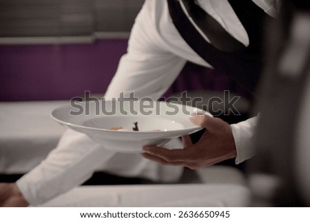 Elegant waiter’s hands in motion while serving gourmet cuisine — a moment of precision, professionalism, and fine dining excellence.