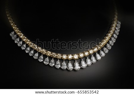 An elegant jewelry. Gold and diamonds necklace on black background.
