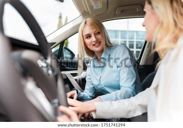 Elegant lady on a test drive with an instructor.\
Woman practiced to drive a\
car