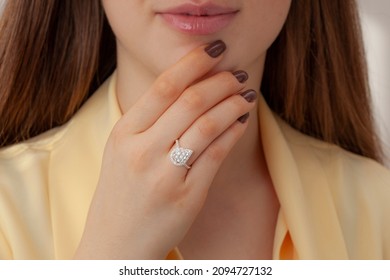 Elegant Lady Pink Outfit Is On Display With Her Brown Nail Polish And Diamond Ring. Diamond Ring Image That Will Increase Online Sales