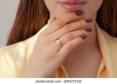 Elegant Lady Pink Outfit Is On Display With Her Brown Nail Polish And Diamond Ring. Diamond Ring Image That Will Increase Online Sales